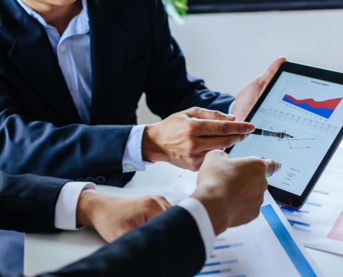 Side view of two financial analysts looking at a tablet