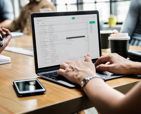 Side view of a woman on her computer in a meeting